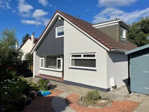 Wall refurbishment of a detached house with a refreshed pebbledash exterior, white wall coating and contrasting grey cladding.