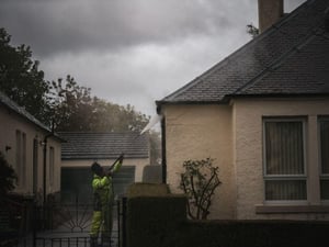 Exterior wall protection being applied to a residential home during heavy rain to help protect the exterior walls.