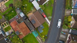 Aerial view of residential roof tiles across a Scottish housing area.