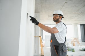 Exterior wall coating being applied to a residential property, showcasing wall refurbishment for improved durability and appearance.