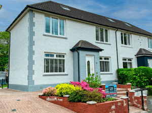 Best exterior wall coatings on a two-storey house, featuring a clean white textured finish, grey detailing and colourful front garden landscaping.